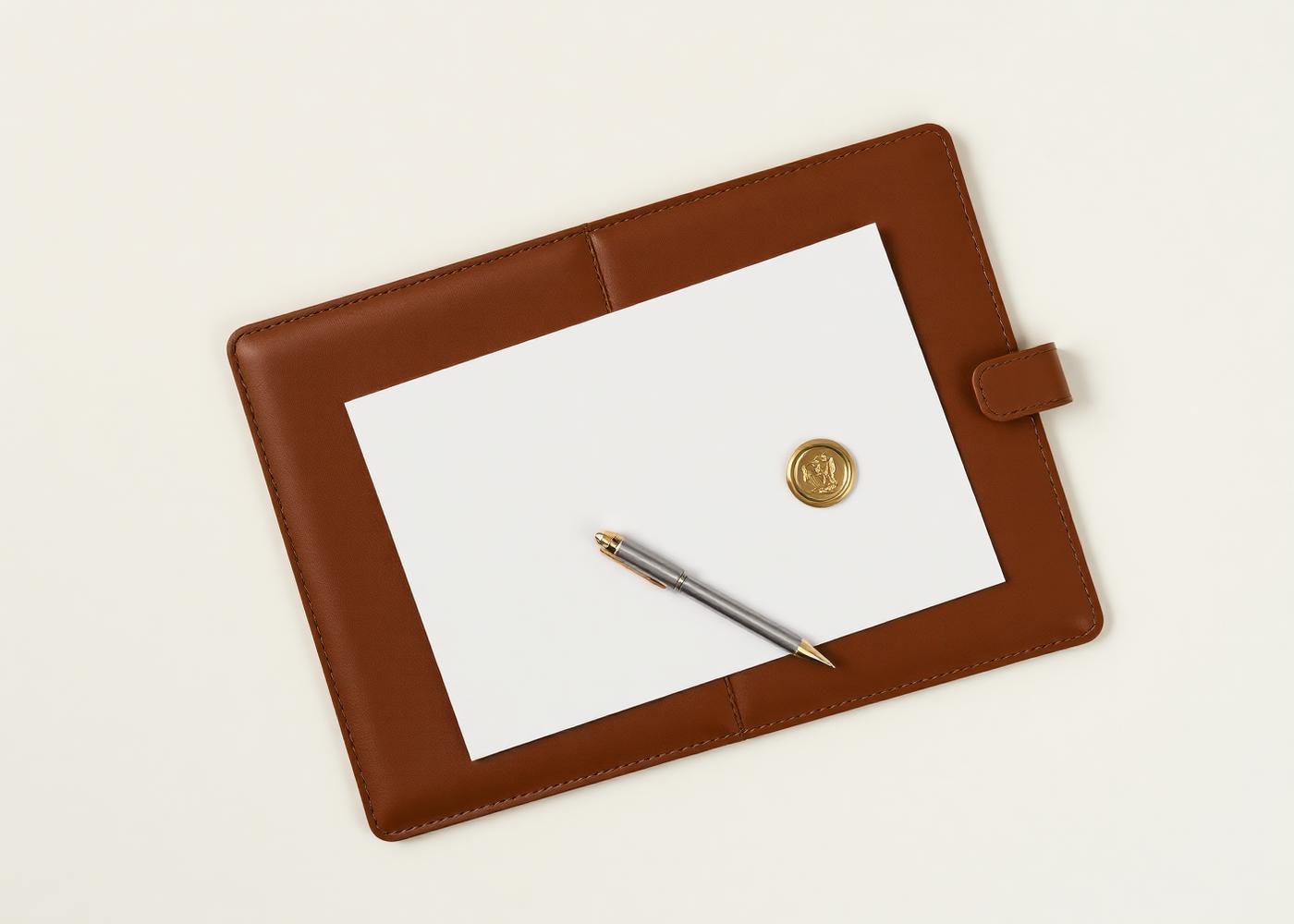 Leather portfolio with a document, brass seal, and pen